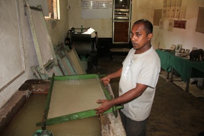 He is sifting water through the paper.