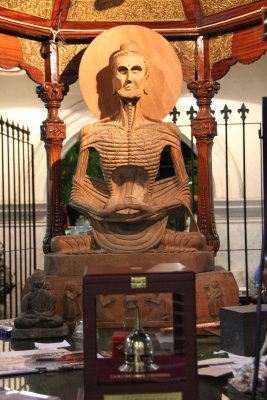 An erie-looking wooden carving with (what looks like) the man's ribs showing.