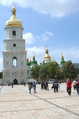 People strolling in front of the bell tower of Saint Sophia Cathedral.