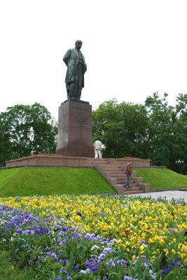 View with flowers of the monument located in a park across from the Red Building.