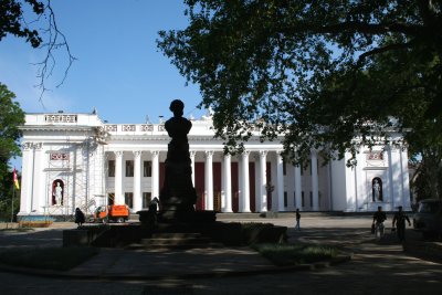 Silhouette of Aleksandr Pushkin monument with the City Hall in the background.