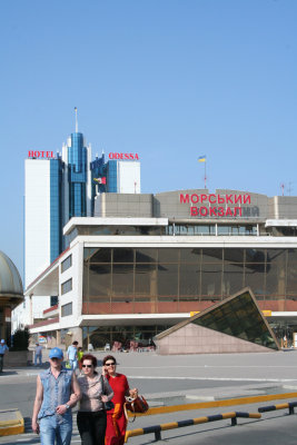 People, a modern sculpture and the Marine Station building at the Odessa pier.