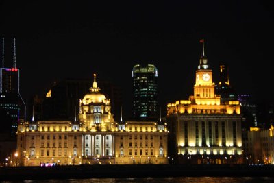 Colonial-era buildings lit up in the Shanghai night including the HSBC Building and the Shanghai Customs House.