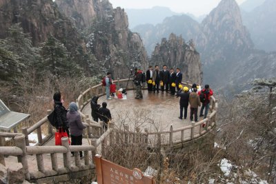 Tourists posing on circular viewing platform on Mount Huangshan.