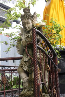 Traditional Balinese statue with religious offering of flowers (on its shoulder).