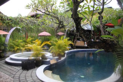 Poolside view with with tropical rain drops splashing in the water.