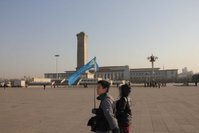 People walking across Tian'anmen Square with the Monument to the People's Heroes in the background.