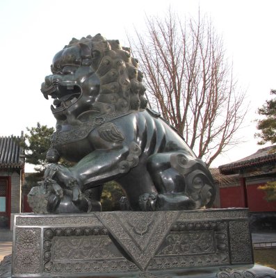 Close-up of guardian lion. It is a male lion because his paw rests on a ball.