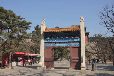 Small entrance door near several tourist shops, in front of the Great Red Gate.