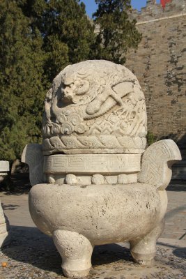 Unusual, stone sculpture with a dragon carving on the top.
