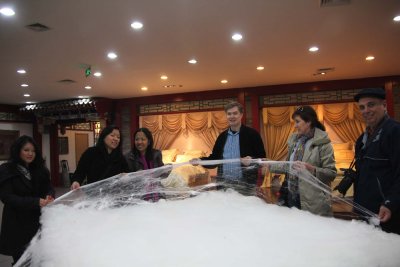 I am with people on my tour holding up the raw silk.
