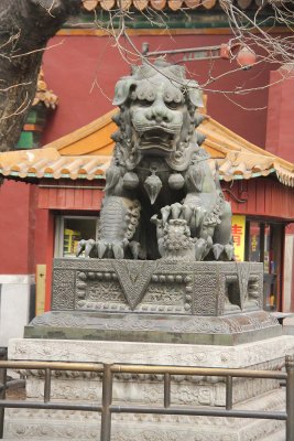 Male lion statue in front of the Lama Temple.