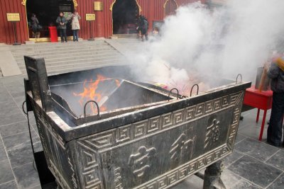 Incense burner flaming and billowing smoke.