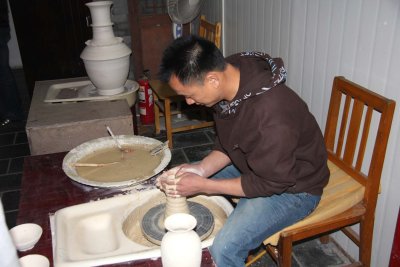 Chinese artisan demonstrating how to make a vase.