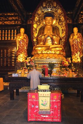 Monk praying in front of the shrine.