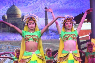 Two beautiful Chinese women dressed in bright green and yellow costumes with tiaras.