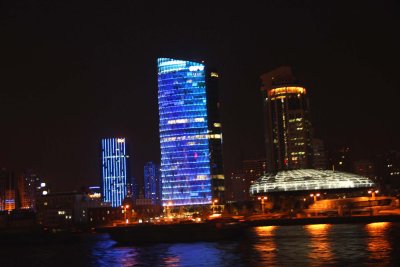 A skycraper illuminated in blue.