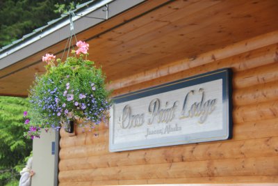 Sign for the Orca Point Lodge with a hanging basket.
