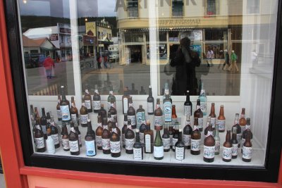 Window of the Mascot Saloon with many Alaskan beers on display.