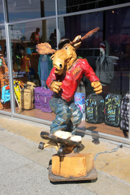 A moose on a skateboard in front of an Anchorage shop.