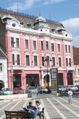 Close-up of Baroque-style building and people hanging out in the square.