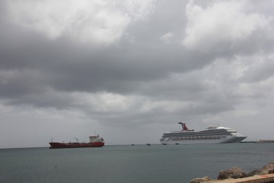 View of the Carnival Victory cruise ship and a commercial ship nearby.