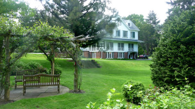 Side view of the Bailey house with benches and trellises in the foreground.