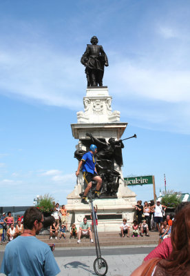 A unicycle performance in front of the monument to Samuel de Champlain.