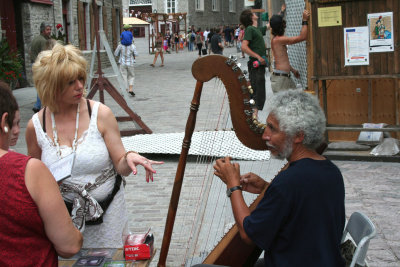 A harpist with admirers playing in Place Royale.