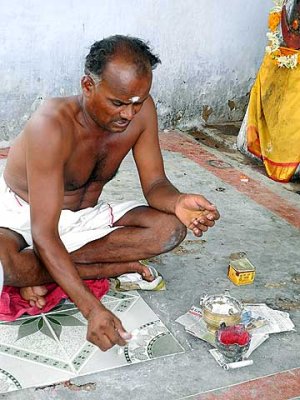 The shaman throws cowrie shells to find out what to do. Tirunelveli District, Tamil Nadu.