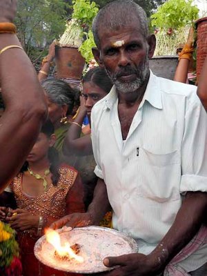 Local priest offering holy fire and ashes to the members of the Mulaipari procession at Koovathupatti, Tamil Nadu. 