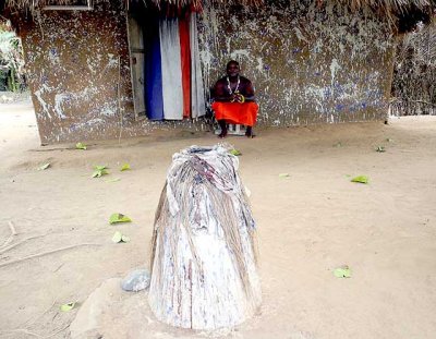 Fetish priest Mensah Gakli and a legba in front of his shrine.