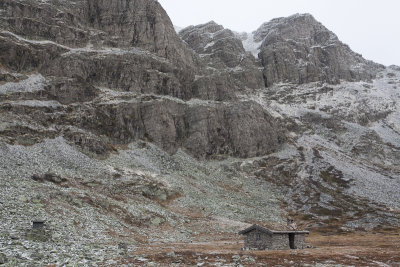 Small stone house beneath big stone mountain