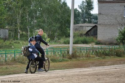 Boys cycling from school in Urnyak