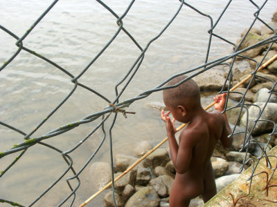 Little boy fishing just outside the hotel grounds