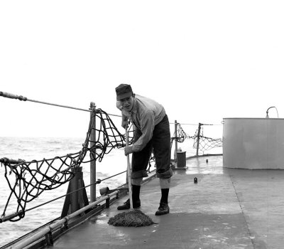 Sailor swabbing deck  on the USS Hugh Purvis, DD 709, in 1962