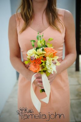 Orange and cream roses, green dendrobium orchids, gold cymbidium orchids, green lisianthus. Photo by Amelia John Photographers