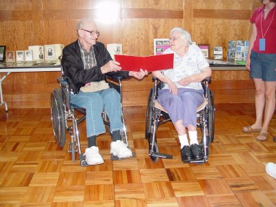 UNCLE BOB AND AUNT ALICE LOOK AT ONE OF THE OLD PHOTOS THAT WERE ON DISPLAY