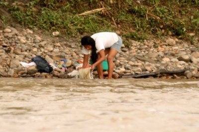 Guaurani washing clothes in Napo River