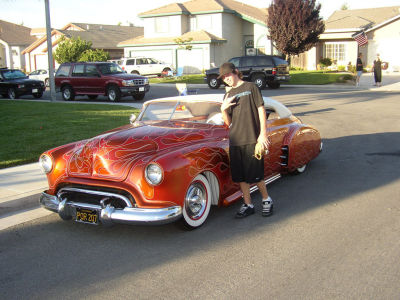 CJ poses next to neighbor's low ride