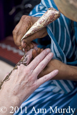 Hands being decorated with henna