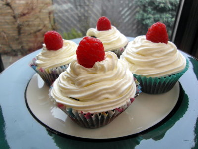 Mocha cupcakes with whipped cream and raspberries.