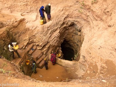 Singing well. Women bringing up water from a well deep underground