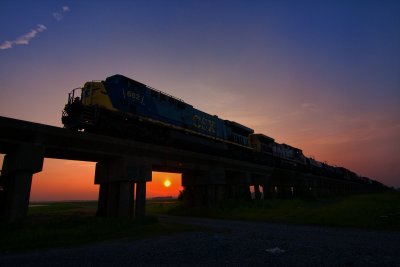 A SB train catches the last sun rays as it moves above the flood plain south of Evansville