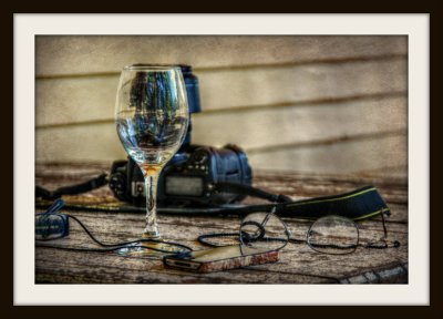 A Wine Glass. Reading Glasses & A Camera