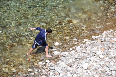 Albanian boy coming wading in the chilly river