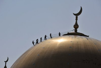 Workers on the roof polishing the dome of the Kipchak Grand Mosque