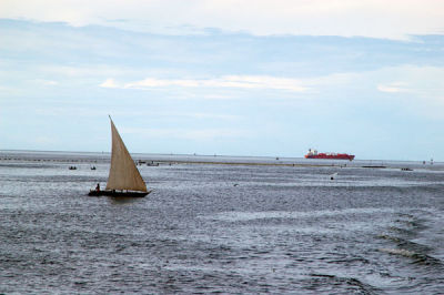Sailboat with a freighter in the distance