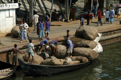 A fully loaded cargo boat carrying giant bundles of things Ive seen lugged all over Dhaka by rickshaw and handcart
