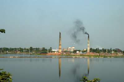 Reflextions of smokestacks in a lake southeast of Dhaka